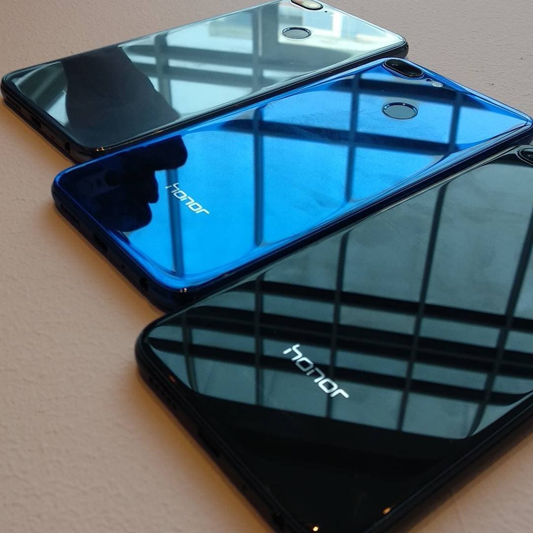 Honor 9 Lite smartphones with glossy glass backs laid on a table