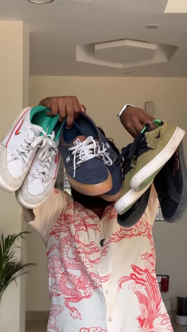 Akio holding up several pairs of sneakers in each hand