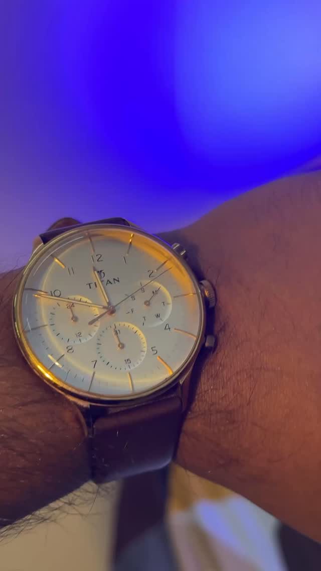Titan Classique watch with a cream dial, gold-tone case and brown leather strap on Akio's wrist