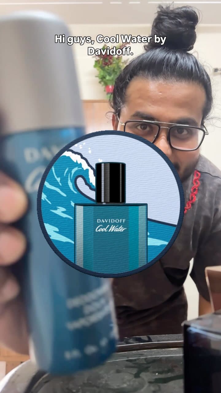 Akio holding a blue bottle of Davidoff Cool Water perfume